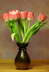 Pale pink tulips in a brown vase
