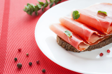 thin ham on a piece of black bread