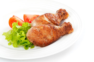 Grilled chicken on a white plate with fresh vegetable