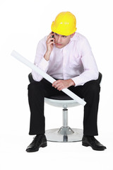 Architect holding plans and telephone