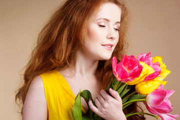 Naklejka na ściany i meble Beautiful redheaded girl with tulips