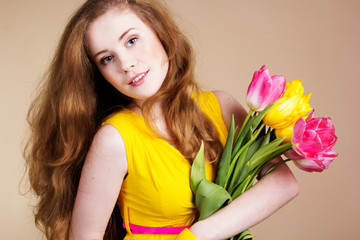 Obraz na płótnie Canvas Beautiful redheaded girl with tulips