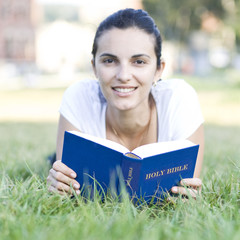 Fototapeta premium woman reading bible on meadow
