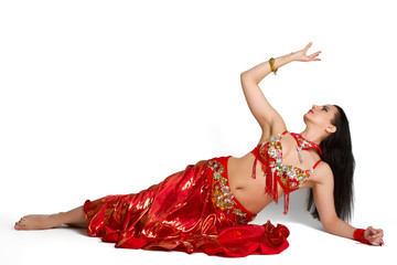 Beautiful young girl in a red suit oriental dance in motion isol