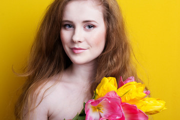 Fototapeta premium Beautiful redheaded girl with tulips