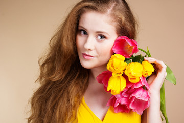 Obraz na płótnie Canvas Beautiful redheaded girl with tulips