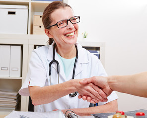 Ärztin reicht Patient ihre Hand