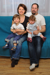 Happy family sitting on blue sofa