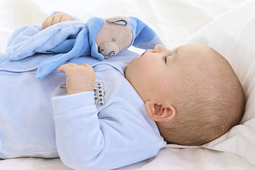 Bébé dort avec son doudou