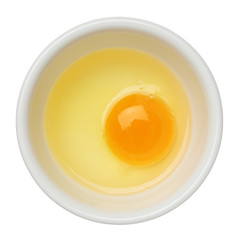 Egg yolk and white in a bowl isolated on white
