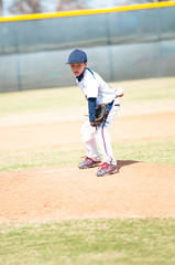 Youth baseball pitcher looking.
