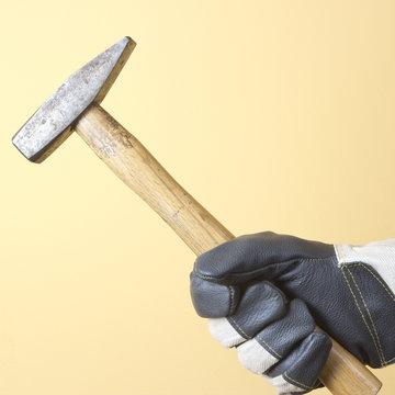 The hand holding the hammer