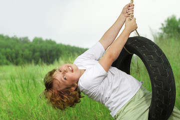 happy boy on swing outdoors