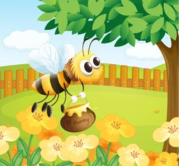 Fotobehang Een bij die honing vasthoudt tijdens het vliegen © GraphicsRF