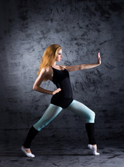 Fototapeta na wymiar Beautiful modern female dancer posing in sporty clothes