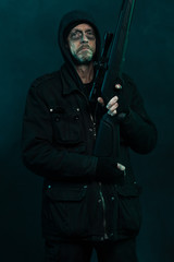 Fototapeta na wymiar Snajper z brodą w czarnym posiadania broni. Studio strzał.