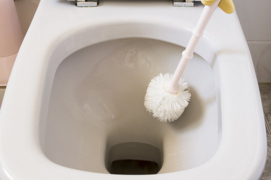 Scrubbing Toilet Bowl With A Toilet Brush