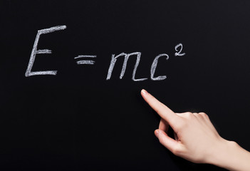 Student hand pointing on phisycs formula.