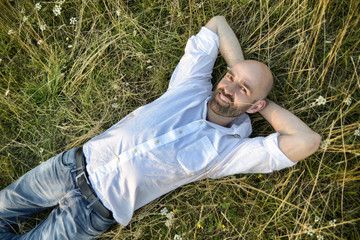 Lachender Mann liegt im Gras