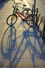 Obraz na płótnie Canvas two bicycles in a rack on the sidewalk