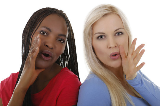 Schwarze und weiße Frau rufen laut - mit Händen am Gesicht