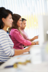 Woman Working At Desk In Busy Creative Office