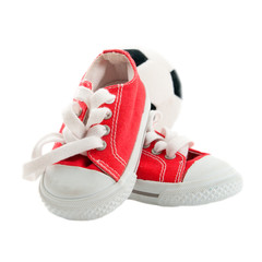 Red baby sneakers with a ball isolated on white