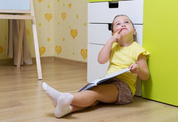 Little thinking girl with book