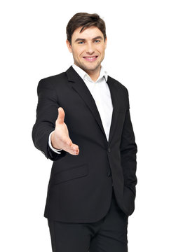 Smiling businessman in black suit gives handshake