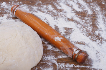 Round the dough and rolling pin on floured table close-up