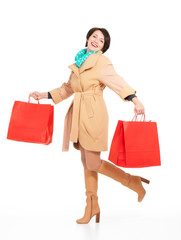 Fototapeta na wymiar Portret szczęśliwa kobieta z torby na zakupy w jesiennym płaszczu