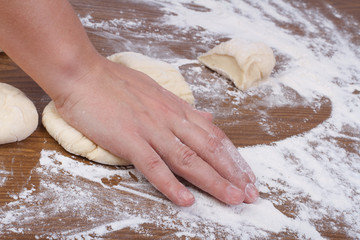 Baker's hand presses down on the dough
