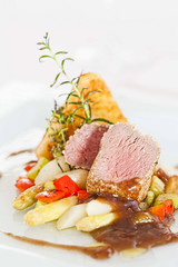 Roasted saddle of lamb on asparagus ragout and herbs