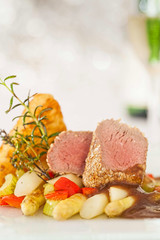 Roasted saddle of lamb on asparagus ragout and herbs