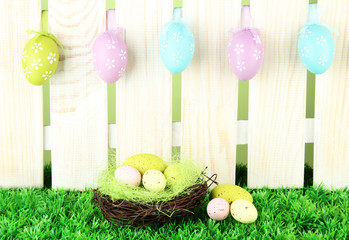 Art Easter background with eggs hanging on fence