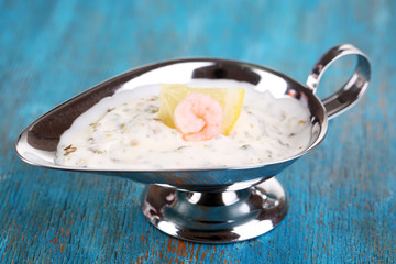 Shrimp in sauce tartare on blue wooden table close-up