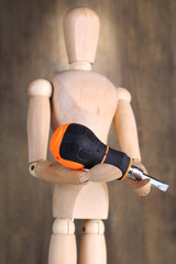 Naklejka premium Mannequin with screwdriver, on grey wooden background