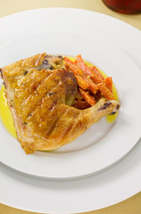 Roasted chicken with vegetables on a white plate