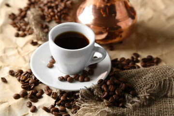 Cup and pot of coffee on beige background