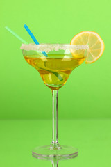 Yellow cocktail in glass on color background