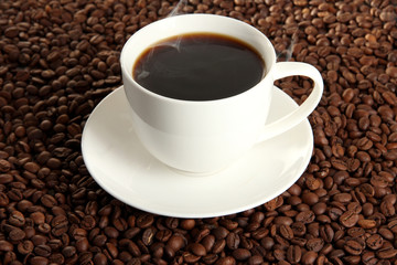 Cup of coffee on coffee beans background