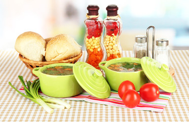 Fragrant soup in pans on table in kitchen