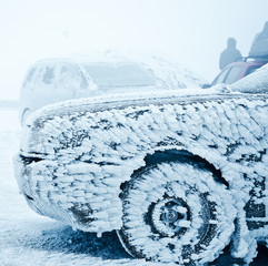 Snow covered frozen car at winter
