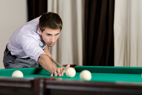 Man playing billiard. Spending free time on gambling