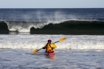 Kayake meeting the  crest of a big wave