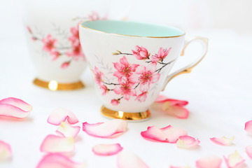 Obraz na płótnie Canvas Pretty tea cups and rose petals
