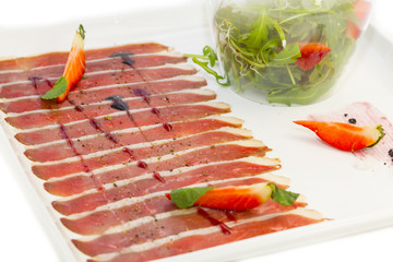 sliced goose meat and a salad of arugula