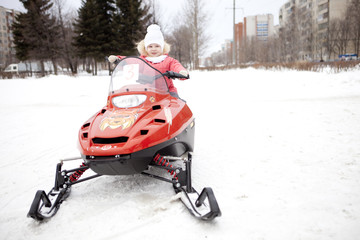 Children are riding on snowmobiles.