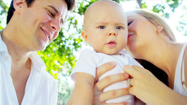 Loving Parents Holding Baby Son Sunshine Outdoors