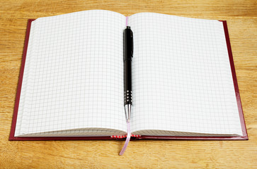 close-up of pen and notebook on wooden desk